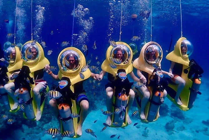 Diver riding a BOSS underwater scooter over a coral reef while snorkeling on St. Thomas USVI